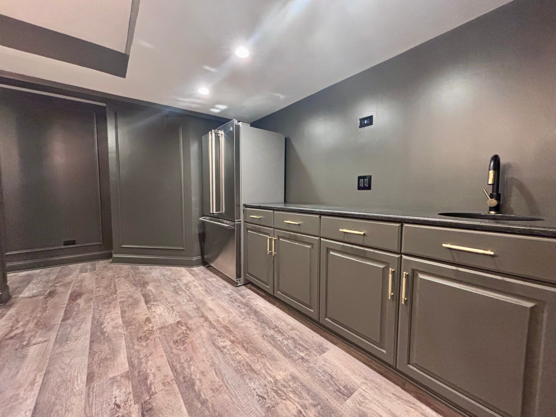 Basement bar with gold hardware and plank flooring