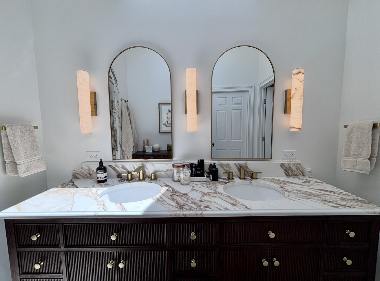 Master bath double vanity with marble counters and arched mirrors