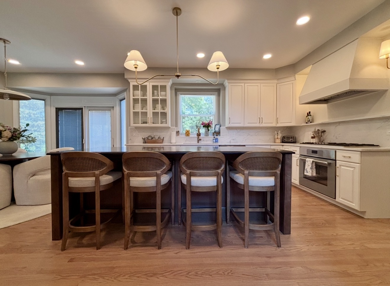 Custom kitchen with white cabinetry, marble backsplash and dark island