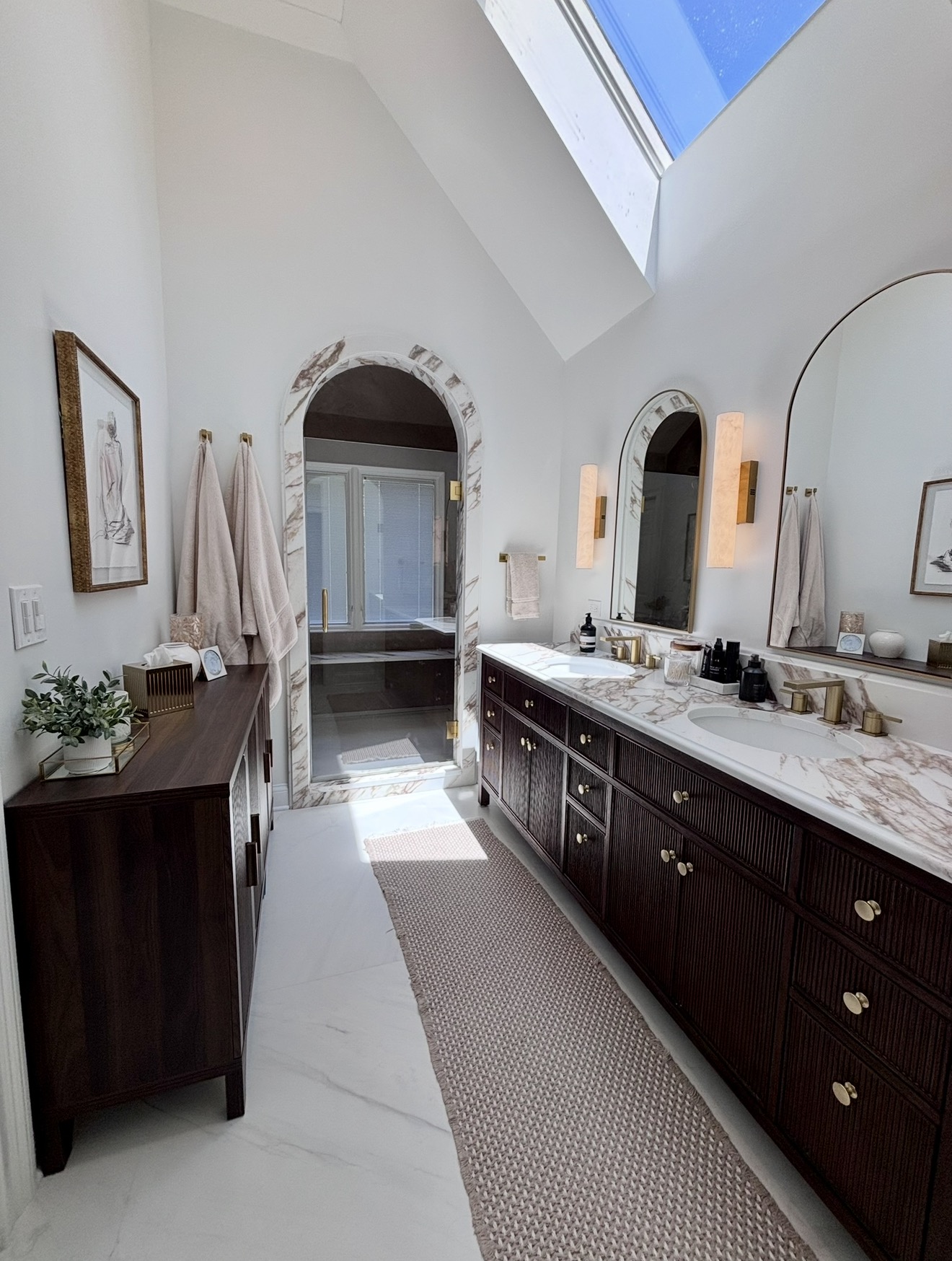 Vaulted master bath with arched marble doorway to shower